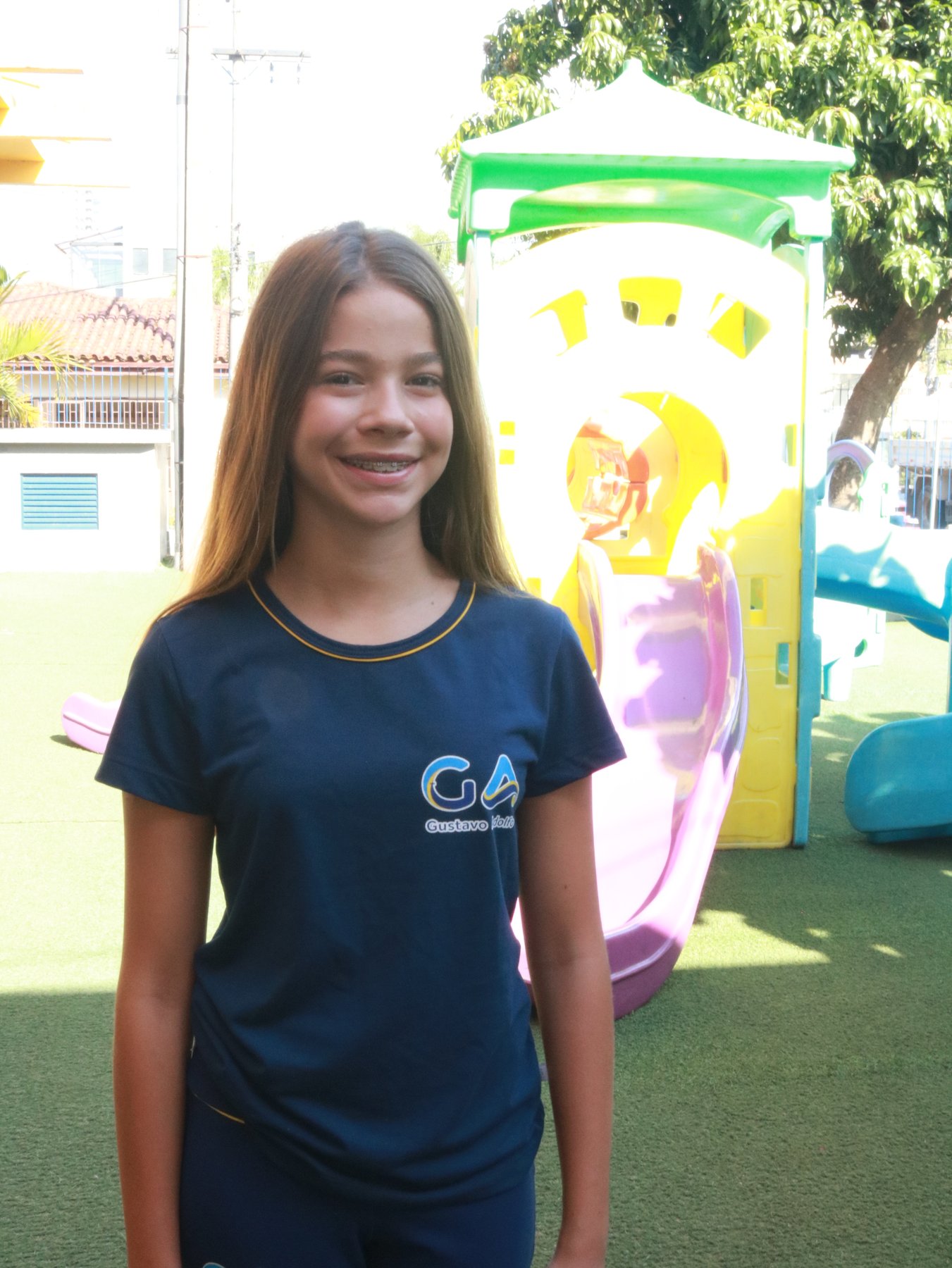 Estudante do GA sorrindo no pátio da escola