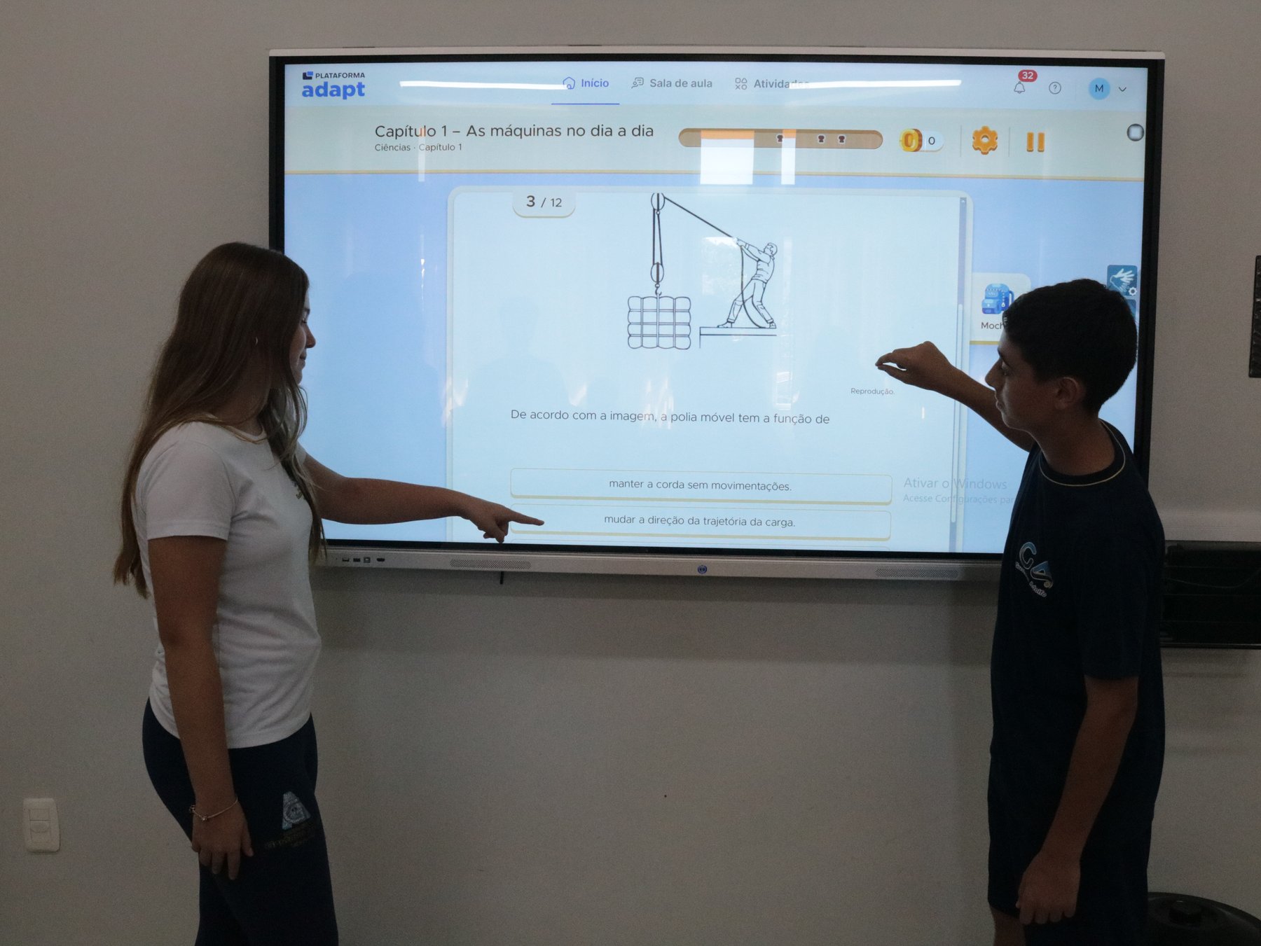 Dois estudantes do GA usando a lousa digital interativa