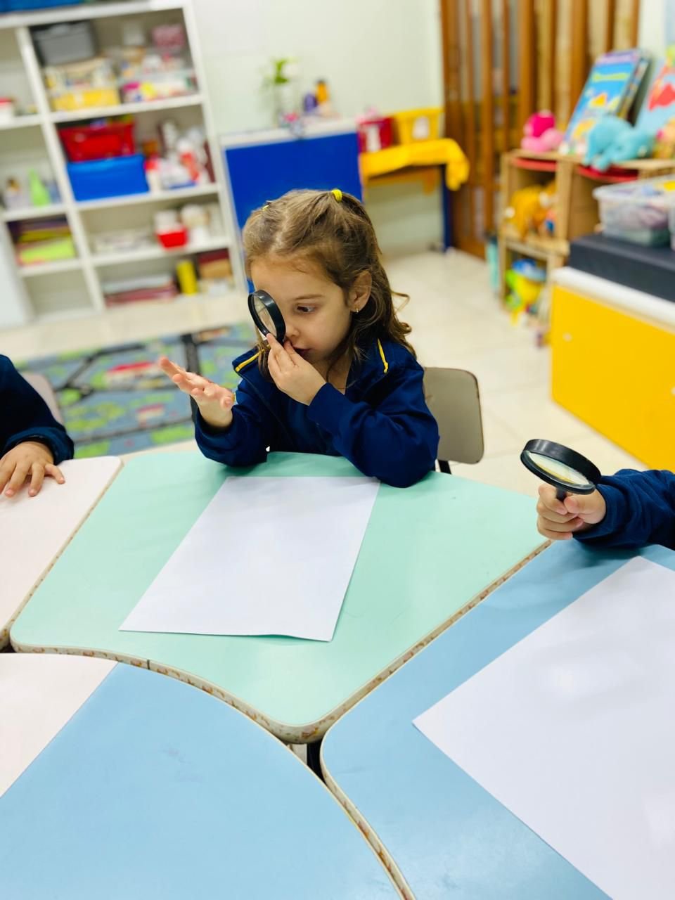 Criança da Educação Infantil do GA observando um objeto com a lupa