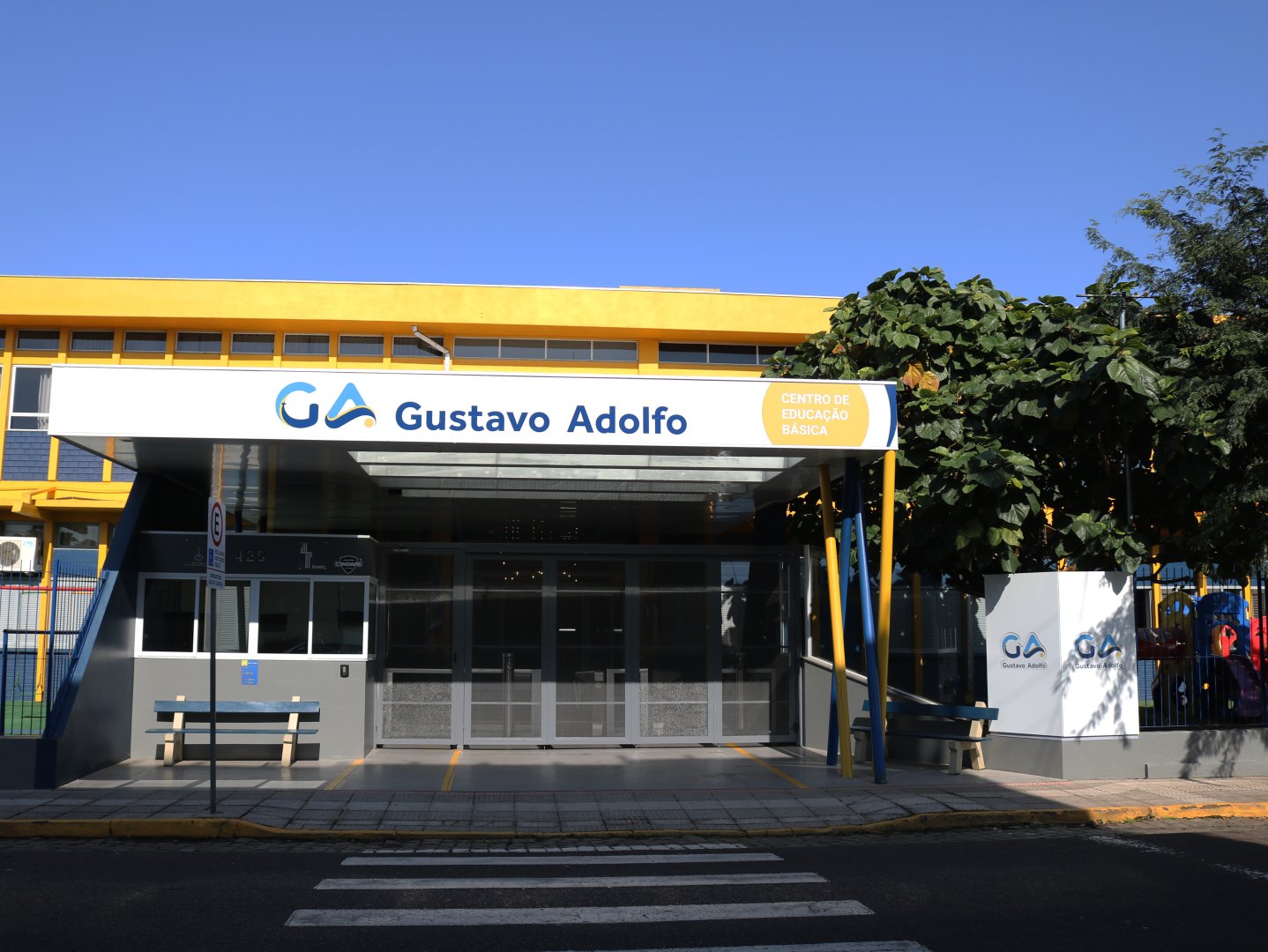 Entrada do Colégio Sinodal Gustavo Adolfo, com marquise amarela e o letreiro da escola